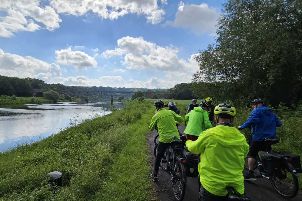 Fahrradgruppe an der Weser mit Ausblick auf Br&uuml;cke