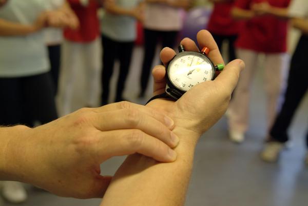 Arm mit Stopuhr - Mensch misst seinen eigenen Puls