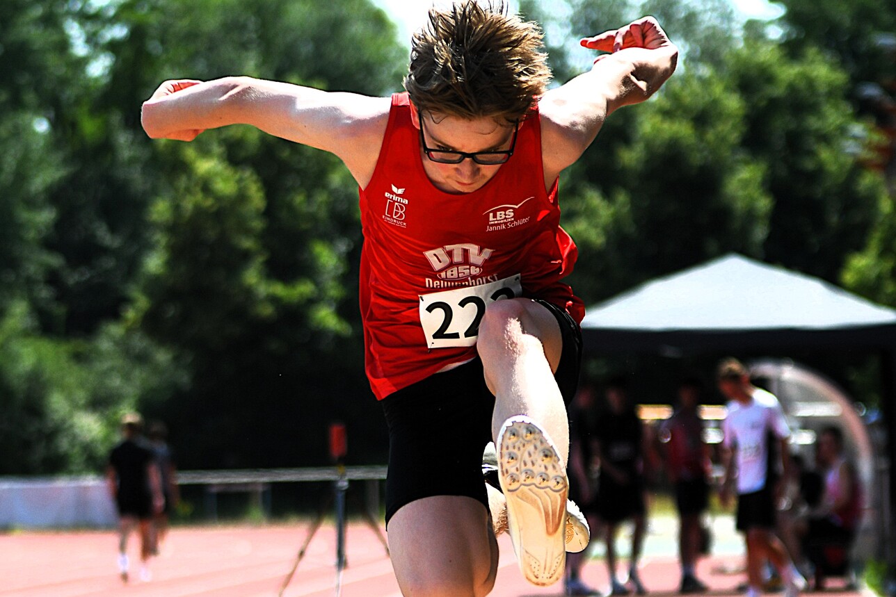 Jonas Lorke im roten Trikot des Sportvereins: Delmenhorster Turnverein von 1856 e.V. beim Weitsprung